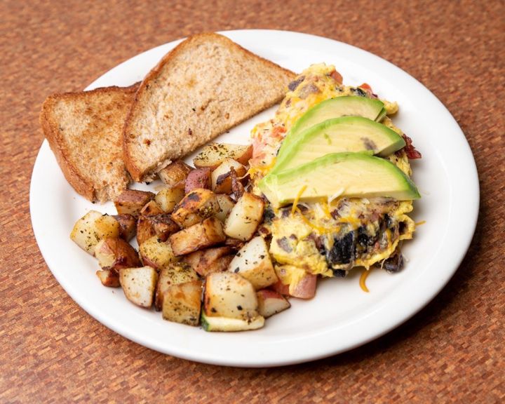 California omelet with sliced avocado, country potatoes and wheat toast