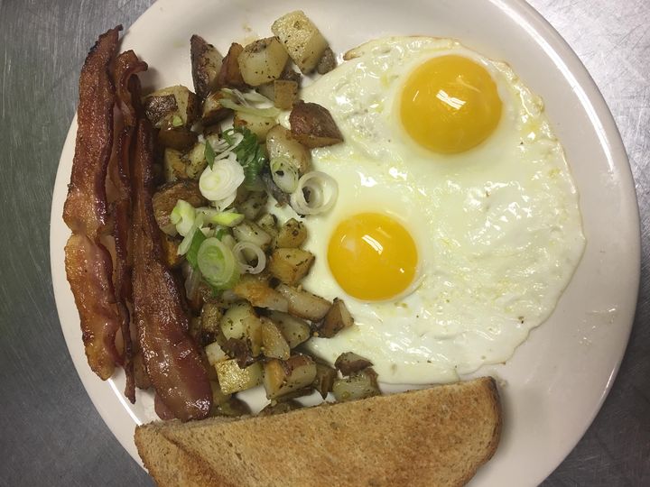 Two eggs, bacon, country potatoes and wheat toast