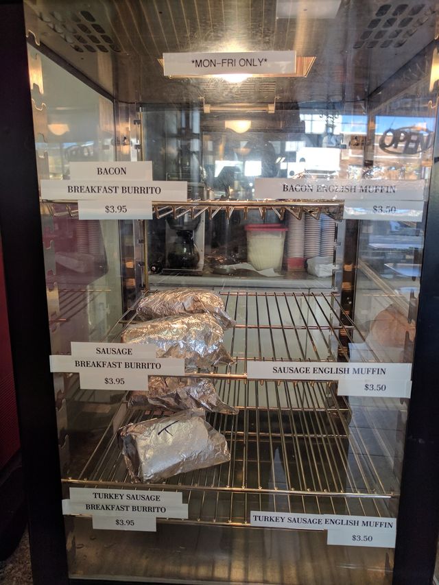 Warmer case with wrapped breakfast burritos and English muffin sandwiches