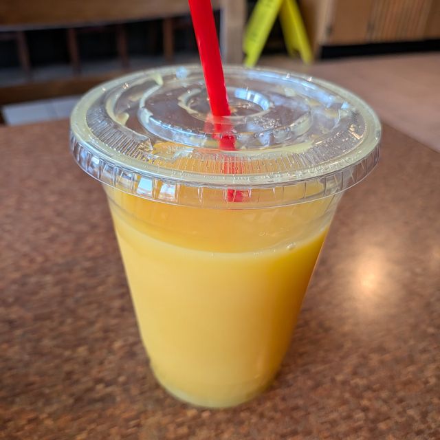 A glass of orange juice on a cafe table